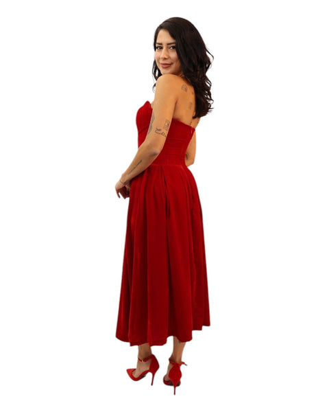 Woman wearing Rose Velvet dress in red with built-in corset and voluminous skirt.